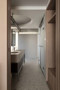 A minimalist bathroom featuring concrete materials and an industrial ceiling light.