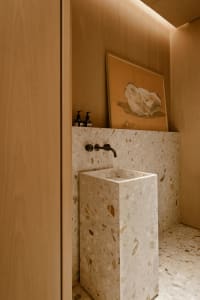 A modern bathroom features a terrazzo sink and minimalist design