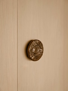A modern minimalist brown door handle with a textured design