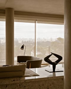 Modern living room with glass walls and a view of the city.