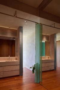 Modern bathroom with marble surfaces and a green curtain.