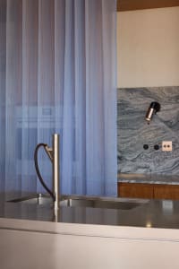 Modern kitchen featuring stainless steel appliances, granite countertops, and a table lamp.