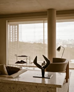 Modern living room with terrazzo countertop and minimalist decor, featuring a sculpture on a table.