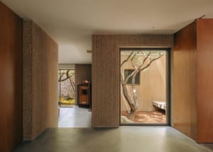 A minimalist residential interior scene with concrete walls and floors.