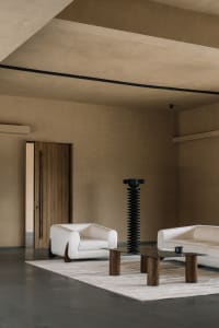 Contemporary interior design featuring a minimalist living room with white furniture and a textured concrete floor and ceilin