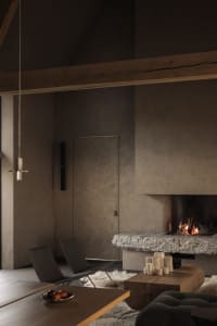 A minimalist living room with concrete walls, a stone fireplace, wooden furniture, and a white fur rug.