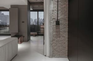 Modern apartment interior featuring exposed brick walls and concrete flooring.