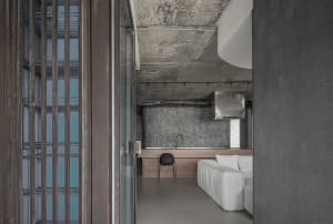 Modern industrial residential kitchen featuring concrete and glass materials.