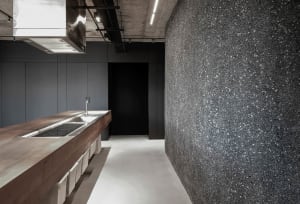 Modern minimalist kitchen with concrete countertop, featuring sleek, clean lines and a monochromatic color palette.