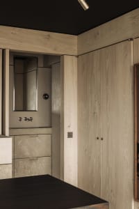 Modern bathroom featuring concrete walls and wooden cabinetry.