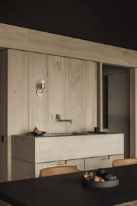 Modern kitchen with minimalist design featuring concrete countertops and cabinets.