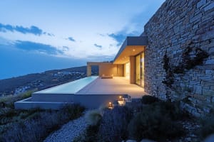 Modern residential pool deck with stone and concrete materials.