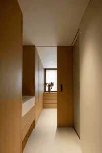 A minimalist interior with wooden cabinets and a white floor.