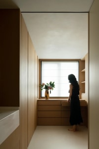 A minimalist interior with wooden trim and a single vase of flowers on a shelf.