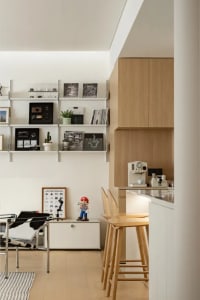 A minimalist home office featuring wooden shelves and modern furniture.
