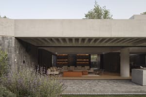 A modern interior space with concrete walls and a garden
