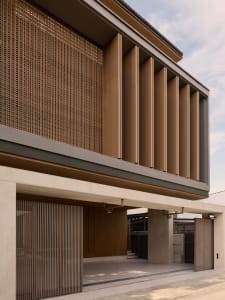 Modern building facade featuring wooden columns and a wooden slat wall.