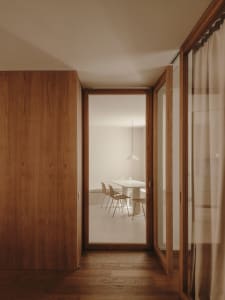 Modern minimalist dining room with wooden floors and furniture.