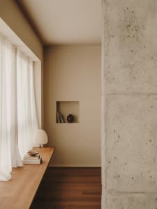 A minimalist interior design featuring wooden furniture and concrete walls.