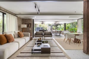A modern minimalist living room with a traditional touch, featuring a white sofa and coffee table, wooden floor, and stone wa