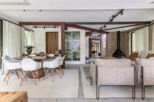 A modern living room featuring wooden furniture, stone walls, and fabric seating.