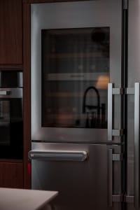 Close-up view of a modern industrial kitchen with a stainless steel wine cooler.