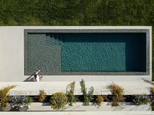 A modern swimming pool with tile surrounding it, viewed from above.