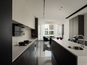 A modern minimalist kitchen with black and white color scheme and marble countertops.