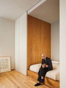A minimalist bedroom featuring a wooden platform bed and a wooden headboard.