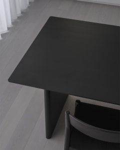 A black wooden table with a sleek, minimalist design.