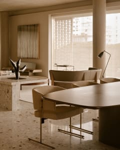 Modern dining room featuring a round table with terrazzo and concrete materials.