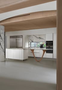 Modern kitchen featuring a marble island and white cabinetry.