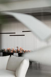 A minimalist dining room adorned with candles and fabric elements.