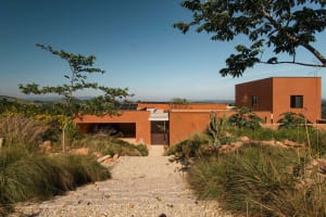 Modern residential house with clay exterior and landscape.