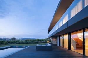 Modern minimalist residential deck with a view, featuring a wooden deck and a white sofa.
