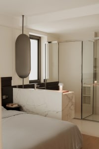 Modern bathroom with marble countertops and glass walk-in shower.