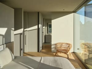 Modern bedroom featuring wooden flooring and minimalist design.