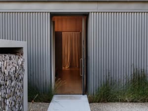 A modern residential entryway featuring corrugated metal walls.