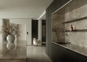 Modern kitchen featuring marble countertops and backsplash, with a large vase of flowers and a sheep figurine.