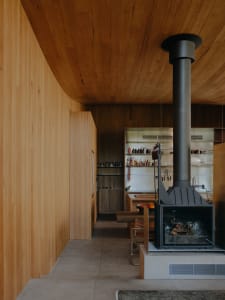 An industrial-style kitchen features wooden walls and a fireplace, creating a cozy and rustic atmosphere.