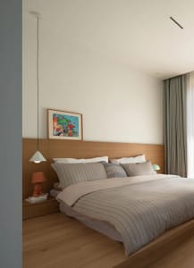 Modern bedroom featuring a wooden platform bed with white bedding and a colorful abstract painting above the headboard.
