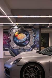 A futuristic metallic garage with a space-themed mural on the wall.