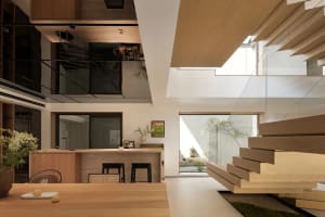 Modern interior design featuring a wooden dining table, glass windows, and concrete elements.