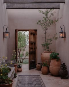 A rustic entryway features terracotta vases and pots, creating a warm and welcoming atmosphere.