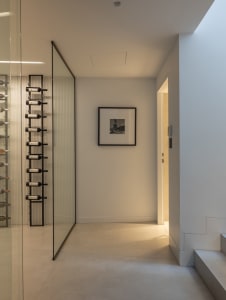 A minimalist storage room with glass walls and a metal ladder.