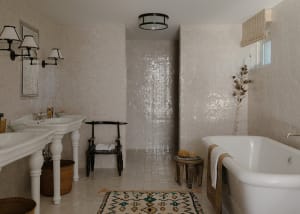 A modern bathroom with white tiles, a white bathtub, and decorative elements.