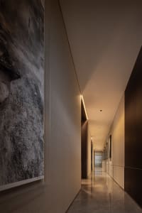 An elegant, metallic modern interior with a long, illuminated corridor.