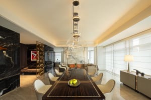 A modern luxury dining room with dark wood table, marble accents, and concrete flooring.