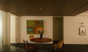 A modern residential interior featuring wood, glass, and metal furnishings
