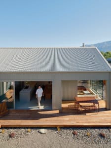 A contemporary house with corrugated metal siding and a wooden deck.